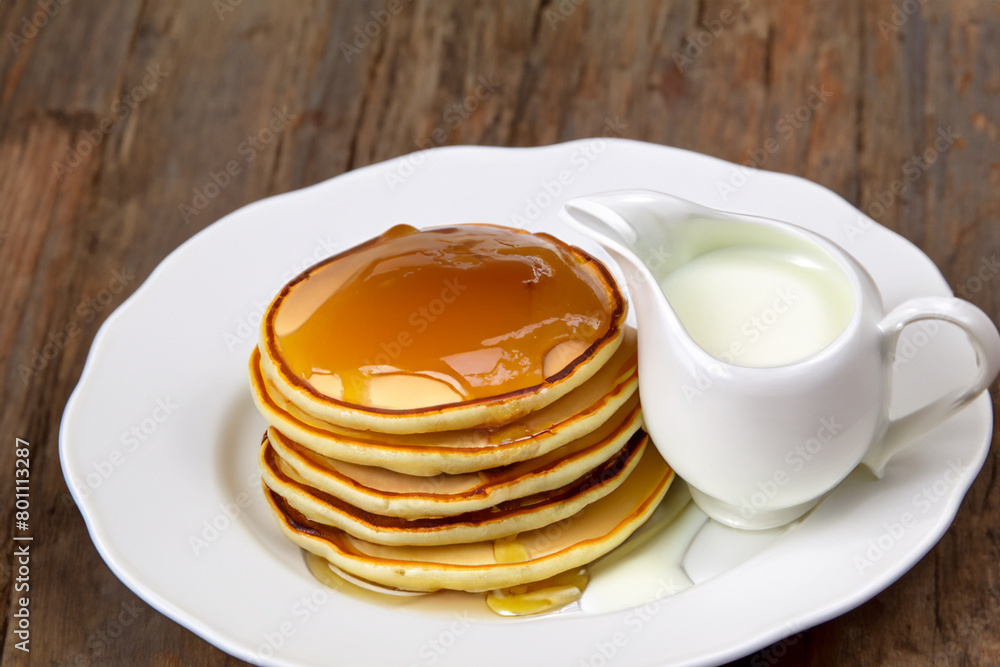 Maslenitsa holiday. on a white plate lies a stack of lush pancakes with honey and sour cream, close-up, sweet concept Maslenitsa holiday. on a white plate lies a stack of lush pancakes with honey and sour cream, close-up, sweet concept