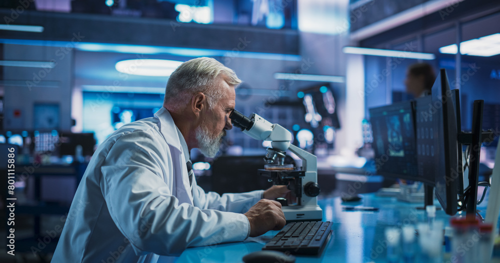 Medical Development Laboratory: Caucasian Male Scientist Using Microscope, Analyzes Petri Dish Sample. Big Pharmaceutical Lab with Specialists Conducting Biotechnology Research, Developing New Drugs. Medical Development Laboratory: Caucasian Male Scientist Using Microscope, Analyzes Petri Dish Sample. Big Pharmaceutical Lab with Specialists Conducting Biotechnology Research, Developing New Drugs.