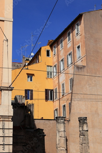 Via delle Botteghe Oscure Street View with Yellow Building Facade and Ancient Columns in Rome, Italy