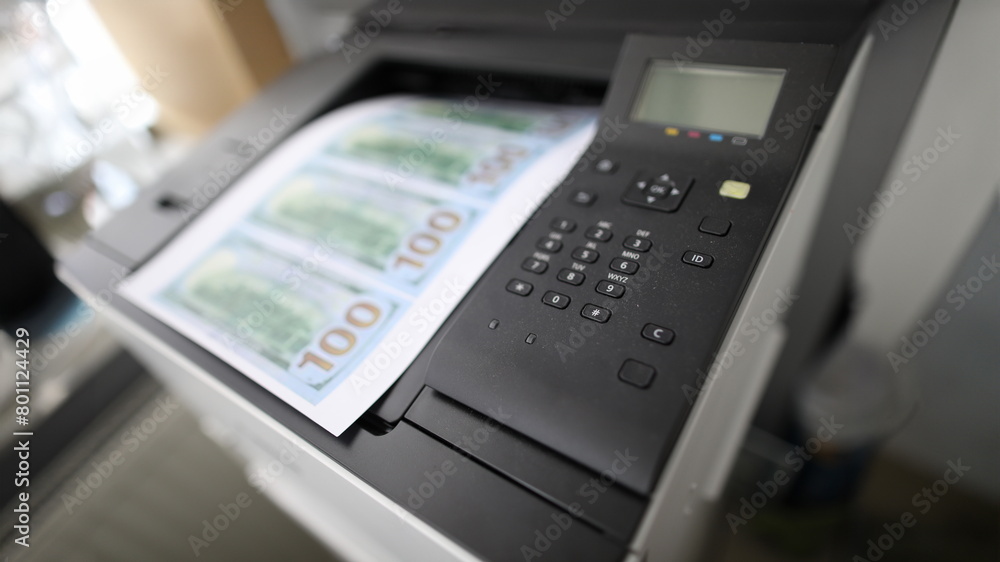 Sheet of paper printed on a printer with fake dollars banknote background Sheet of paper printed on a printer with fake dollars banknote background