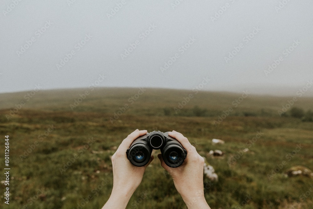 Bird watcher holding binoculars in Scottish Highlands Bird watcher holding binoculars in Scottish Highlands