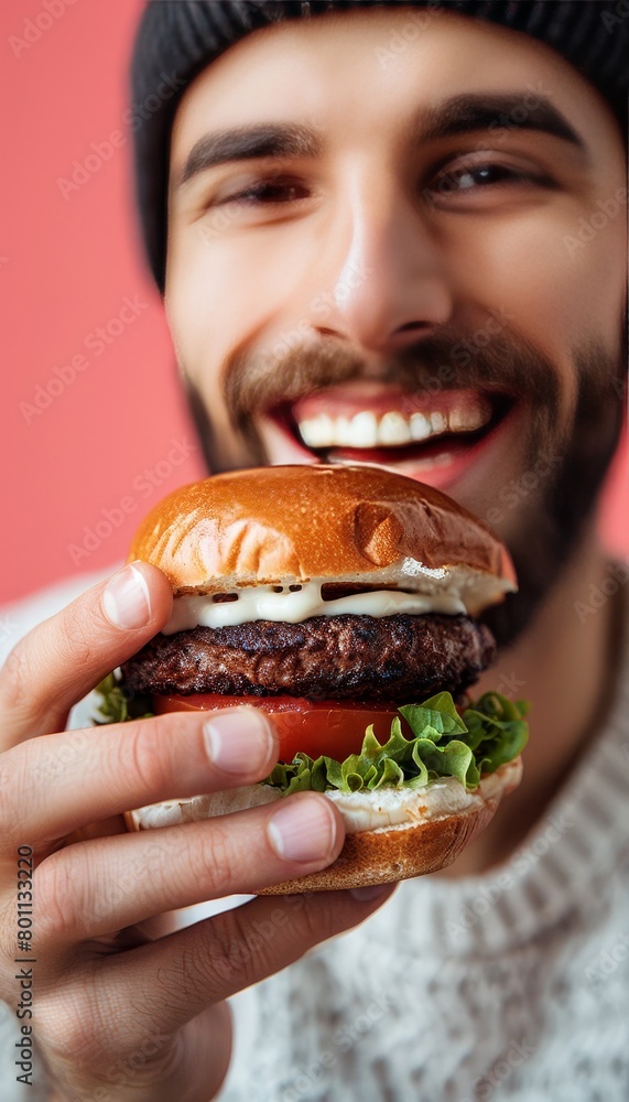 Man enjoying tasty burger in portrait on soft colored backdrop with room for text Man enjoying tasty burger in portrait on soft colored backdrop with room for text