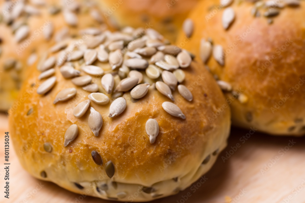 buns with seeds. on a wooden table lies a large number of small round fluffy buns sprinkled with sunflower seeds, close-up top view, concept of bakery products buns with seeds. on a wooden table lies a large number of small round fluffy buns sprinkled with sunflower seeds, close-up top view, concept of bakery products