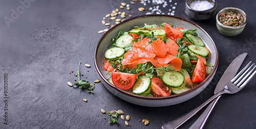 Delicious juicy salad with salmon tomatoes cucucmber herbs salt and spices