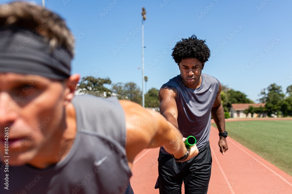 Fototapeta premium Team mates passing a relay baton