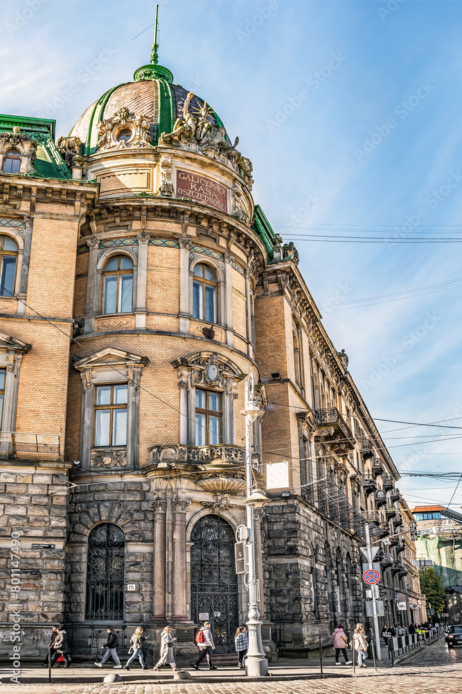 Lviv, Ukraine - November 2,2023: People walk on a street corner past the former building of the Galician Savings Bank in Lviv. Vertical cityscape with ancient architecture in style of late historicism