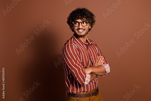 Photo of nice young man look empty space wear striped shirt isolated on brown color background