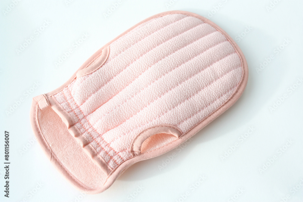 A washcloth is a mitten for washing the body. A pink washcloth white background with copy space. A washcloth is a mitten for washing the body. A pink washcloth white background with copy space.