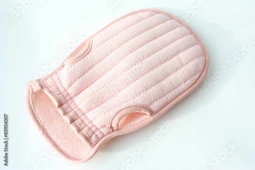A washcloth is a mitten for washing the body. A pink washcloth white background with copy space.