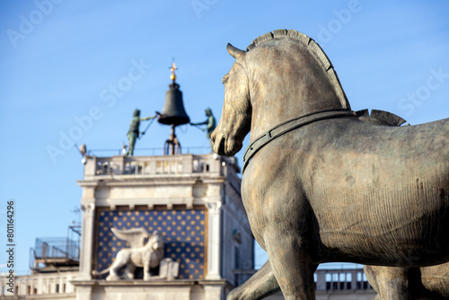 View of Horses of Saint Mark and the winged lion at the Clock Tower defocused in the background on a beautiful sunny day in Venice; Italy