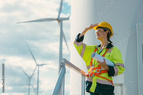Obraz na płótnie female engineer working outdoor with safety at wind turbines clean energy power station background, worker people with renewable energy technology for future concept. w salonie