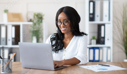 Beautuful black businesswoman working with laptop computer at desk in office photo