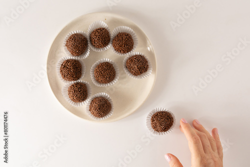 Chocolate truffle ball Brigadeiro brazilian candy and chocolate flakes aerial view clean background