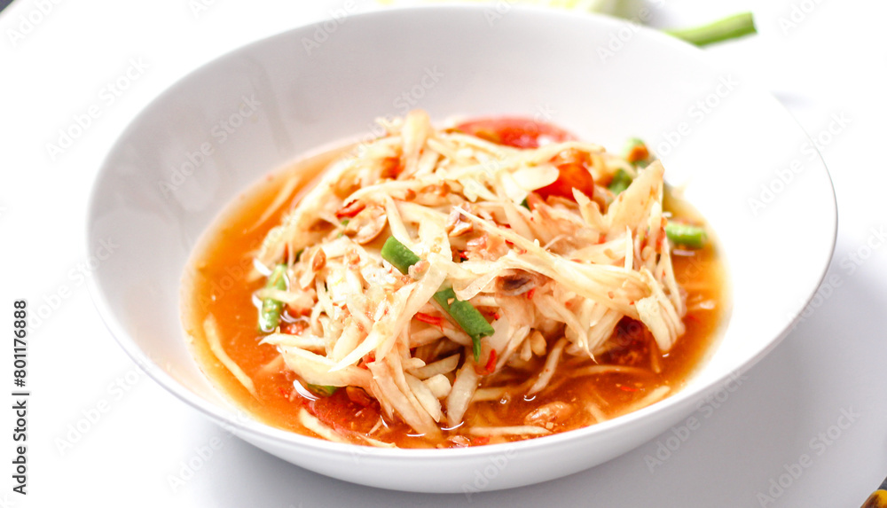 Somtum - Thai spicy papaya salad on white dish Somtum - Thai spicy papaya salad on white dish