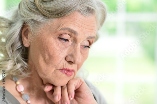 Close up portrait of sad senior woman at home