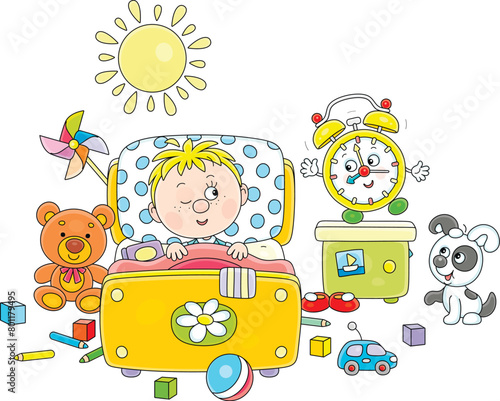 Little boy awaking up in his pretty small bed among toys after merry rings of a funny alarm clock in a nursery room on a sunny morning  vector cartoon illustration isolated on a white background