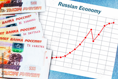 Banknotes of Russian ruble and rising chart of Russian economy.