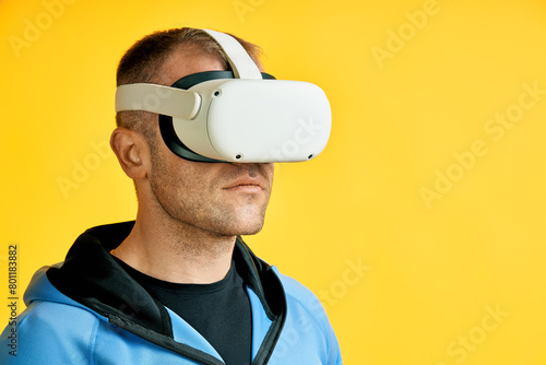 Man wearing virtual reality goggles over yellow background