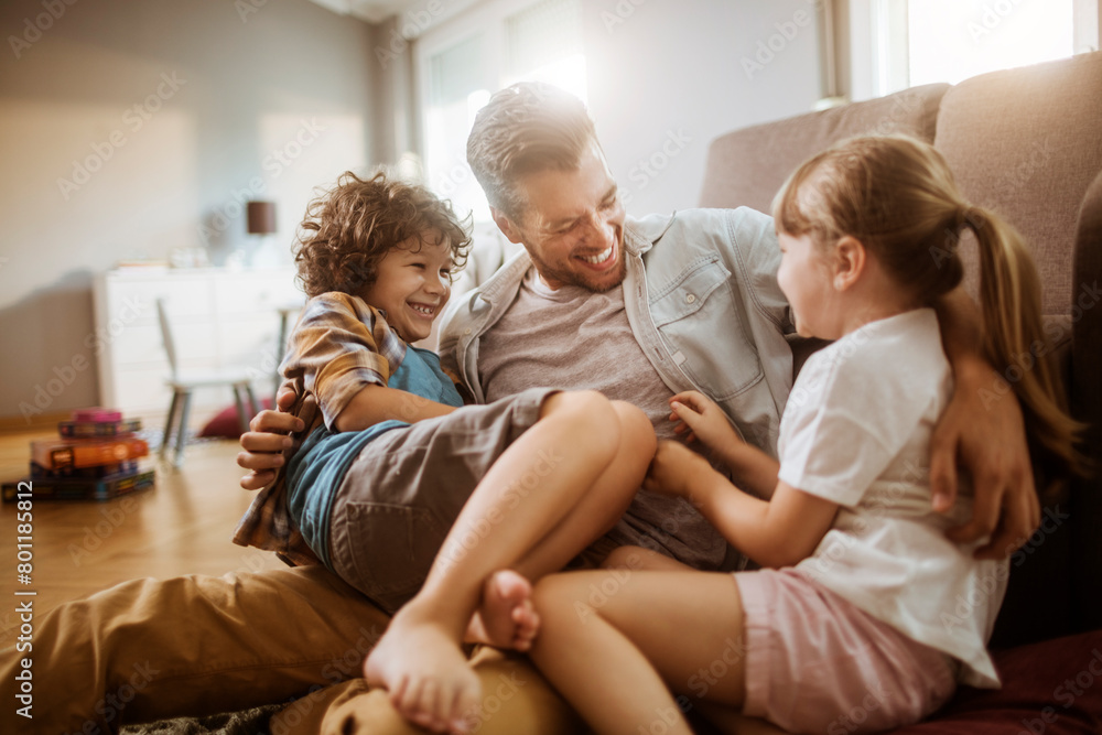 Happy father playing with son and daughter at home Happy father playing with son and daughter at home