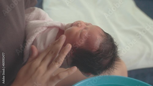 Close up hands of mother cleaning on newborn baby's face