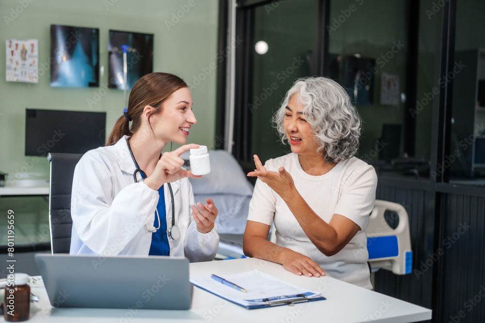 Fototapeta premium Monthly health check-ups and counseling sessions are provided to an elderly Asian woman by a Caucasian female caregiver, offering support, advice, and motivation.