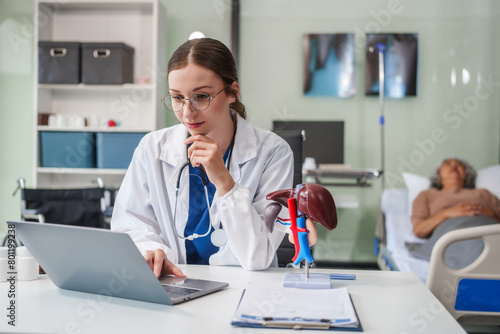 A female Caucasian specialist doctor sits at her desk  specializing in gastrointestinal and liver medicine at the Gastrointestinal and Liver Disease Center.