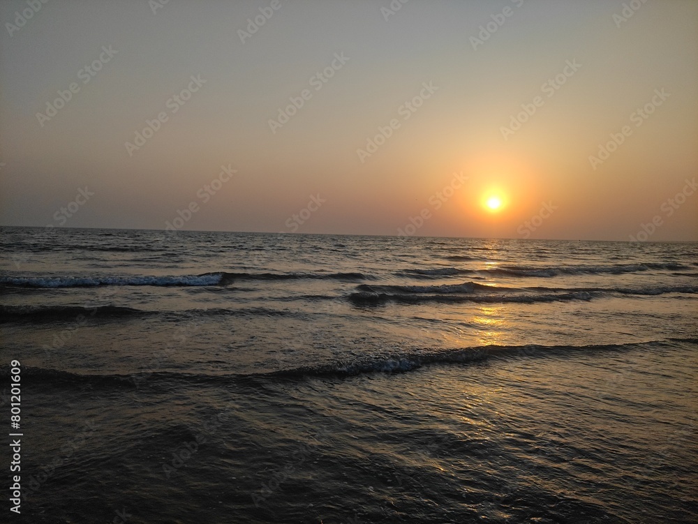 At dusk, the picture depicts a calm beach scene. At dusk, the picture depicts a calm beach scene.