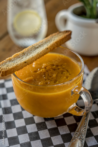 pumpkin soup in glass cup with toast ready to eat