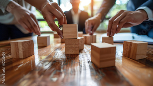 Team of business people playing with block in office