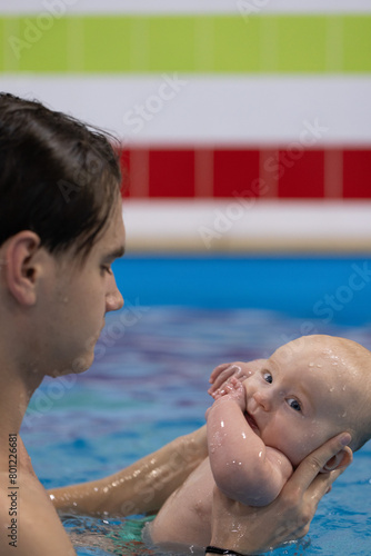 Swim lessons with the newborn in a swimming pool. Closeup.