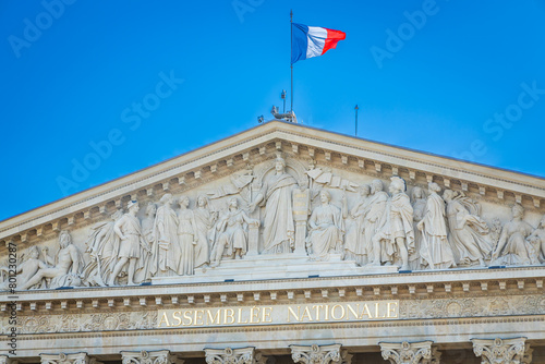 French flag and facade of the Assemblée Nationale building in Paris, France