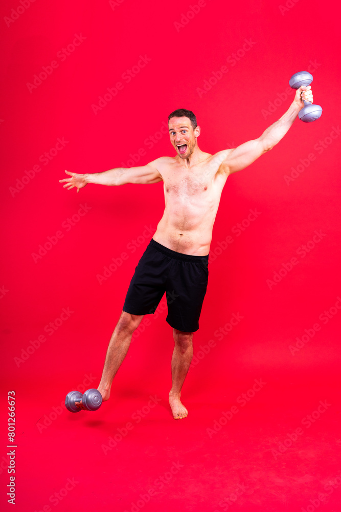Exercising weight training man with a dumbbell isolated studio background, sport and fitness concept