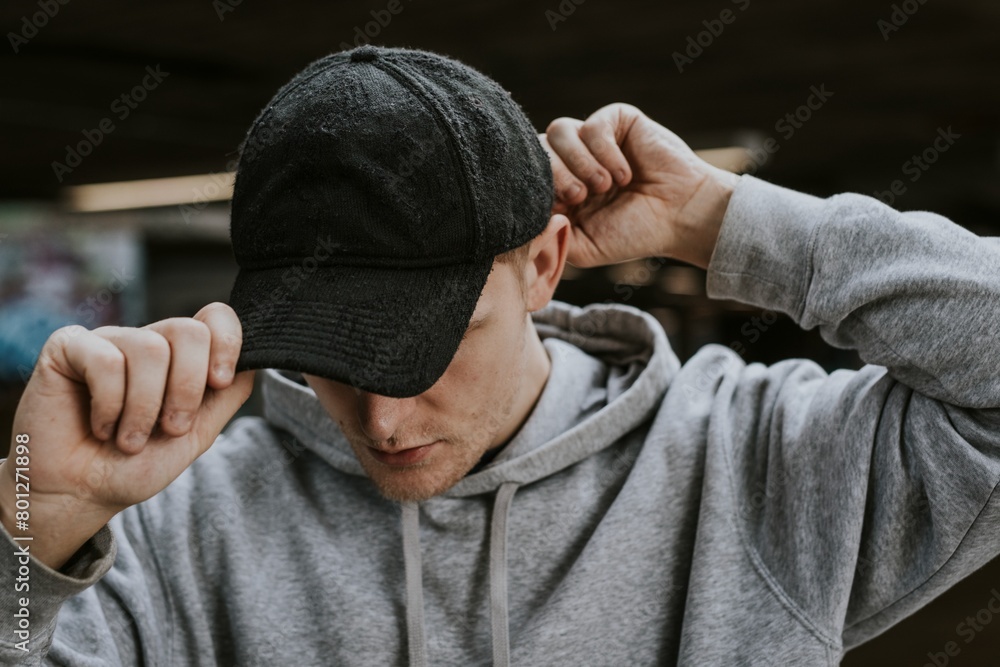 Man in gray hoodie wearing black cap Man in gray hoodie wearing black cap