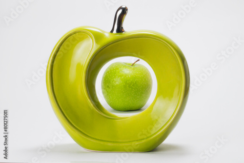 Natural green apple inside a ceramic apple on white background photo
