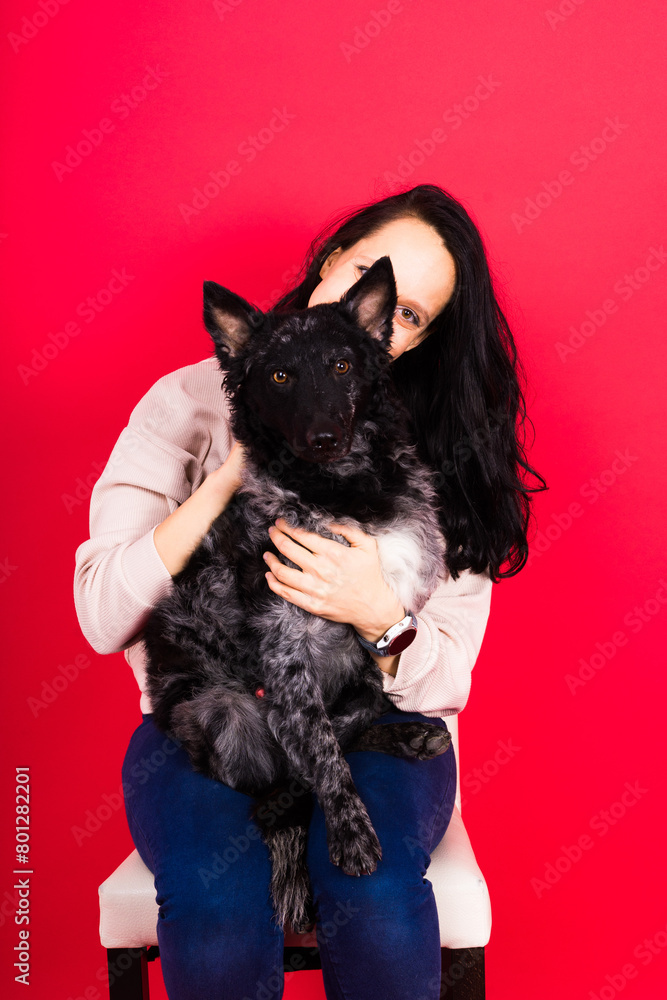 Happy brunette lady in casual wear hugging mudi pet dog, studio background. Happy brunette lady in casual wear hugging mudi pet dog, studio background.