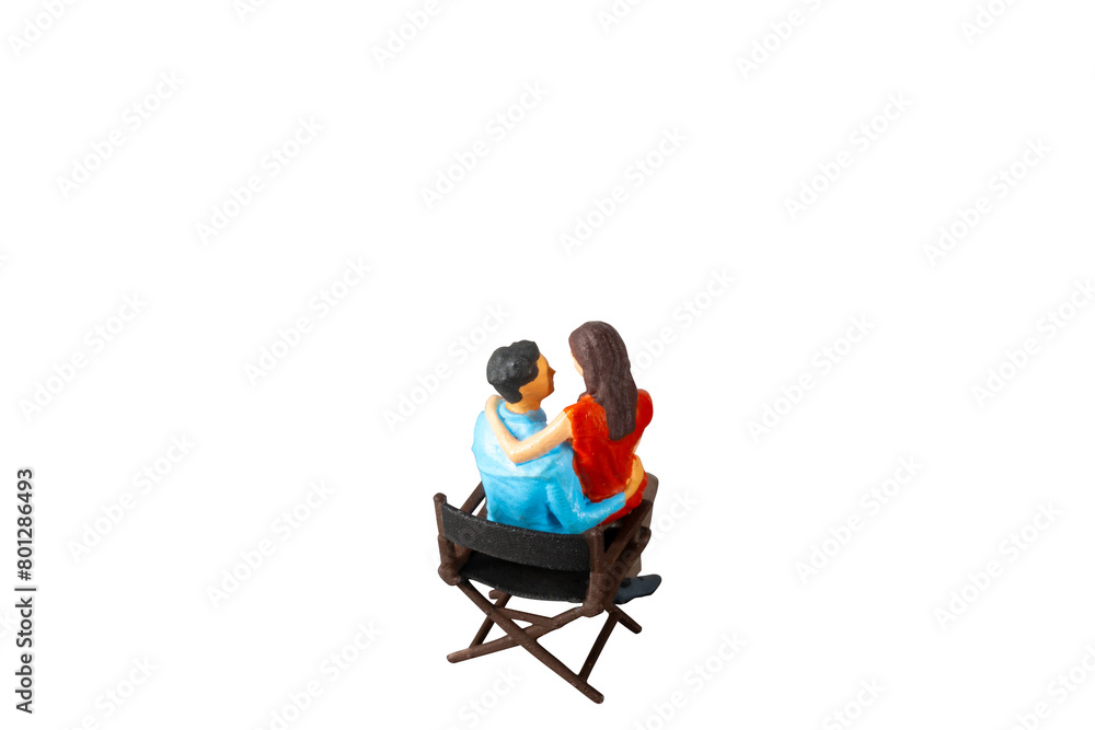 Miniature people , young man and woman sit together on chair Isolated on white background with clipping path Miniature people , young man and woman sit together on chair Isolated on white background with clipping path