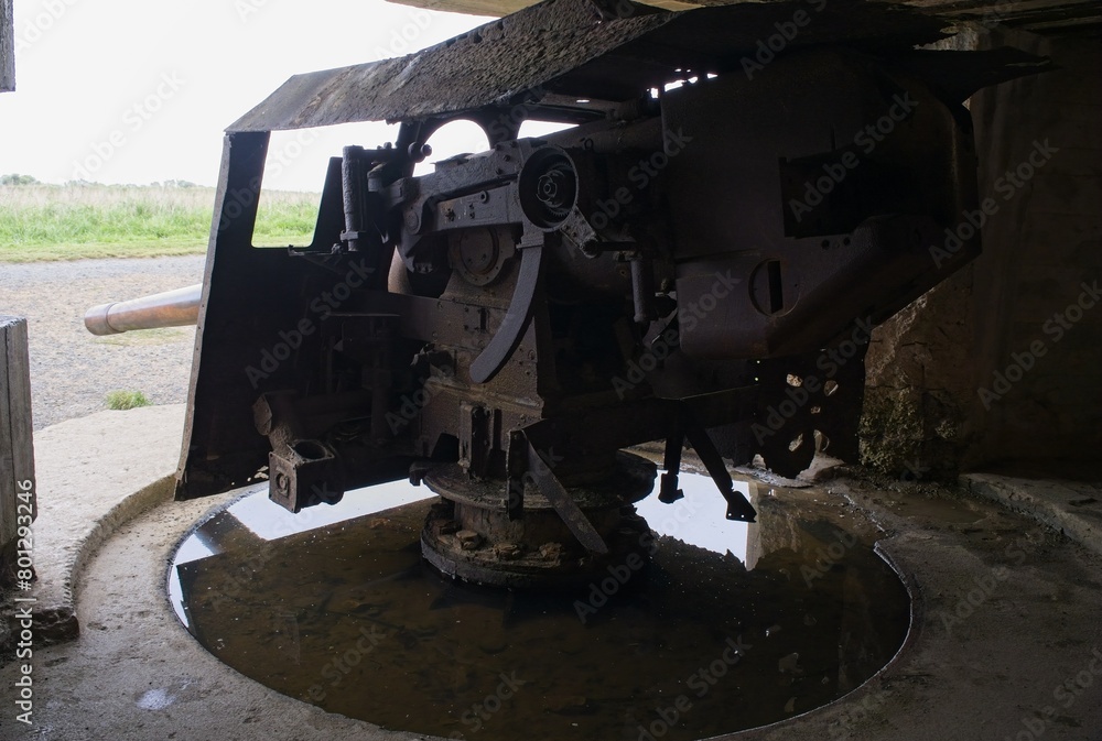 Longues-sur-Mer, France - Apr 26, 2024: German Longues-sur-Mer battery during Second World War. It is the only one in the region to have kept its guns. Rainy spring day. Selective focus. Longues-sur-Mer, France - Apr 26, 2024: German Longues-sur-Mer battery during Second World War. It is the only one in the region to have kept its guns. Rainy spring day. Selective focus.