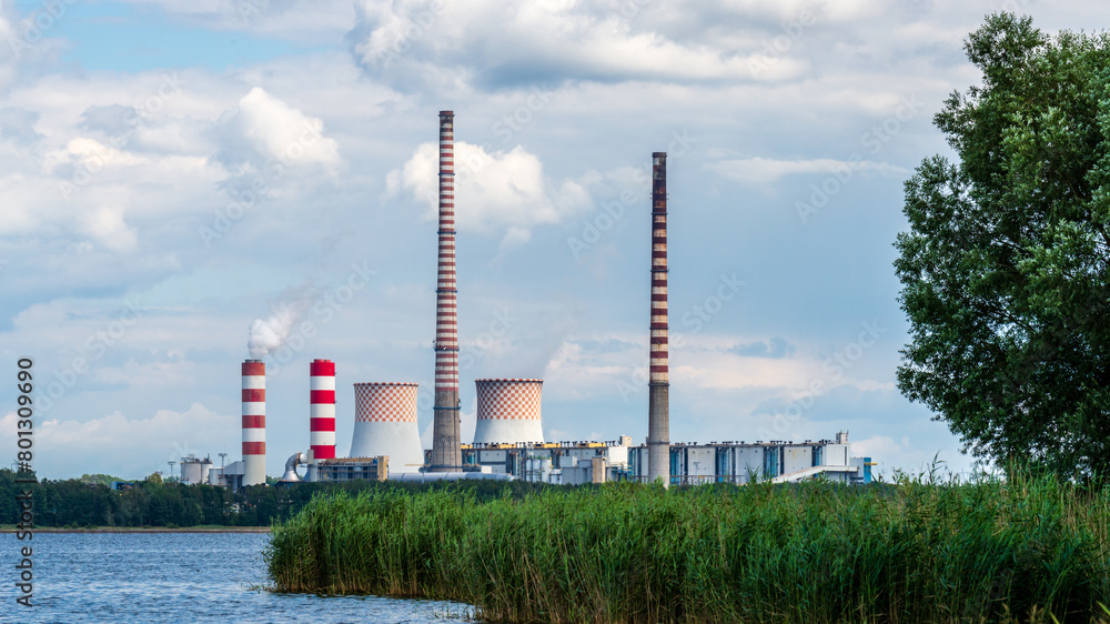 Rybnik power station at Lake Rybnickie (Poland). White smoke comes up a chimney close to the characteristic red and white checkered cooling towers.
