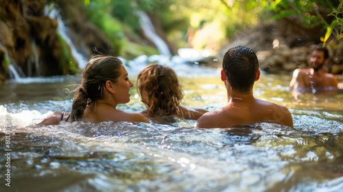 A group of individuals enjoying a swim in a river on a sunny day  surrounded by nature