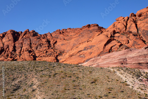 USA, Nevada, Red Rock Canyon.Montagne à la roche rouge de Red Rock Mountain dans un canyon désertique de buissons secs et de cailloux.
