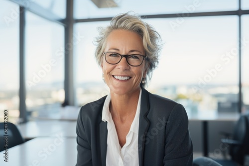 Confident, mature Caucasian businesswoman planning on a tablet in her office. A passionate leader and successful entrepreneur with grey hair smiles and brainstorms