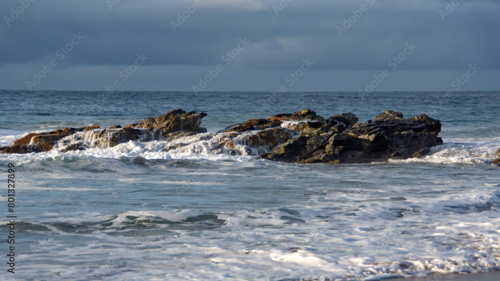 Waves breaking over rocks just off the beach in Zipolite, Mexico Waves breaking over rocks just off the beach in Zipolite, Mexico