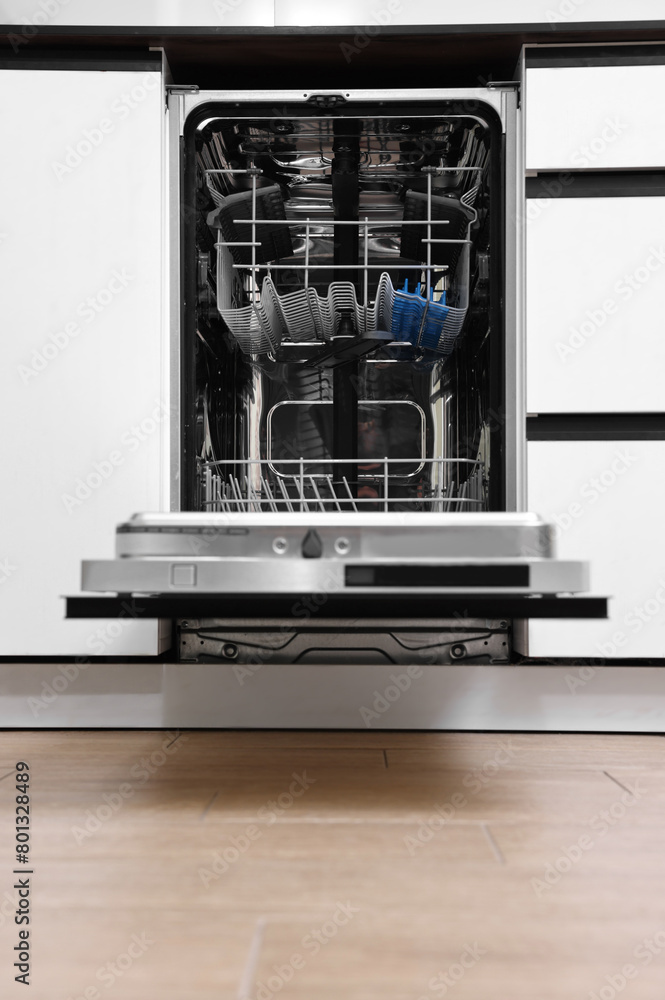 Built-in dishwasher with open door indoors. Home appliance Built-in dishwasher with open door indoors. Home appliance