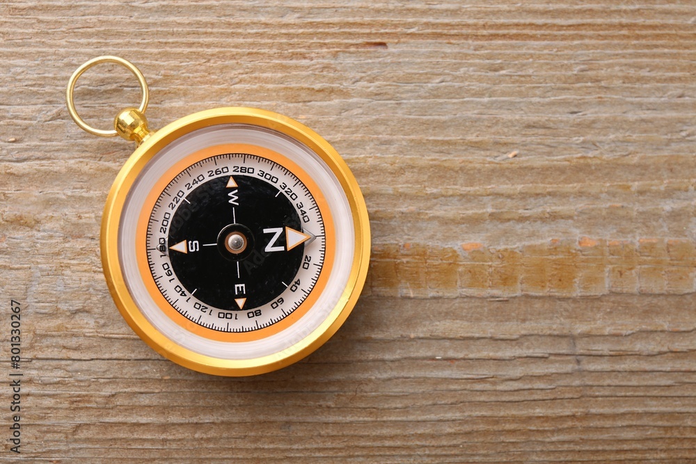 One compass on wooden table, top view. Space for text One compass on wooden table, top view. Space for text