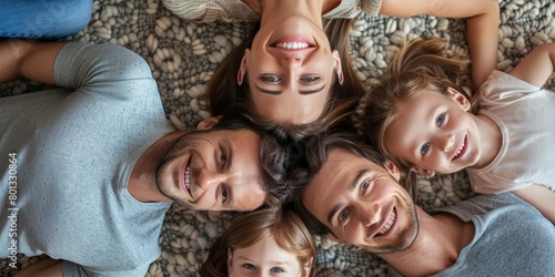 A young family takes selfies on the floor in a circle. Happy parents connecting with their kids at home. Happy siblings relaxing indoors © LukaszDesign