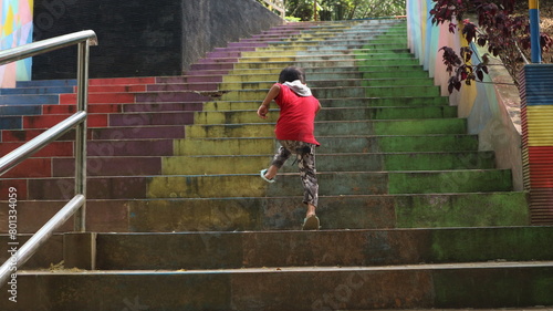 boys playing in the park, running up the colorful stairs