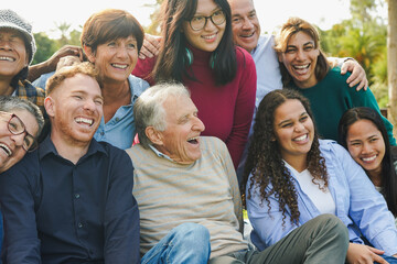 Crowd of multi generational people having fun together at city park - Multiracial community and social inclusion concept