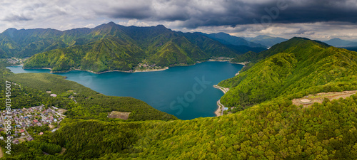 Fototapeta Naklejka Na Ścianę i Meble -  Panoramic aerial view of a lake surrounded by rugged mountains and forest (Saiko)