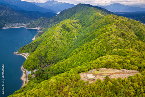 Aerial view of lush forest, mountains and an observation point above a deep lake