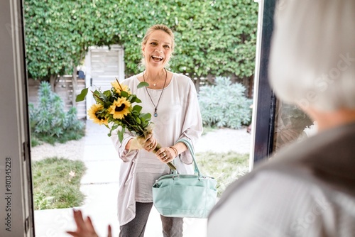 Fotografija Mature woman holding sunflower bouquet, visiting neighbour